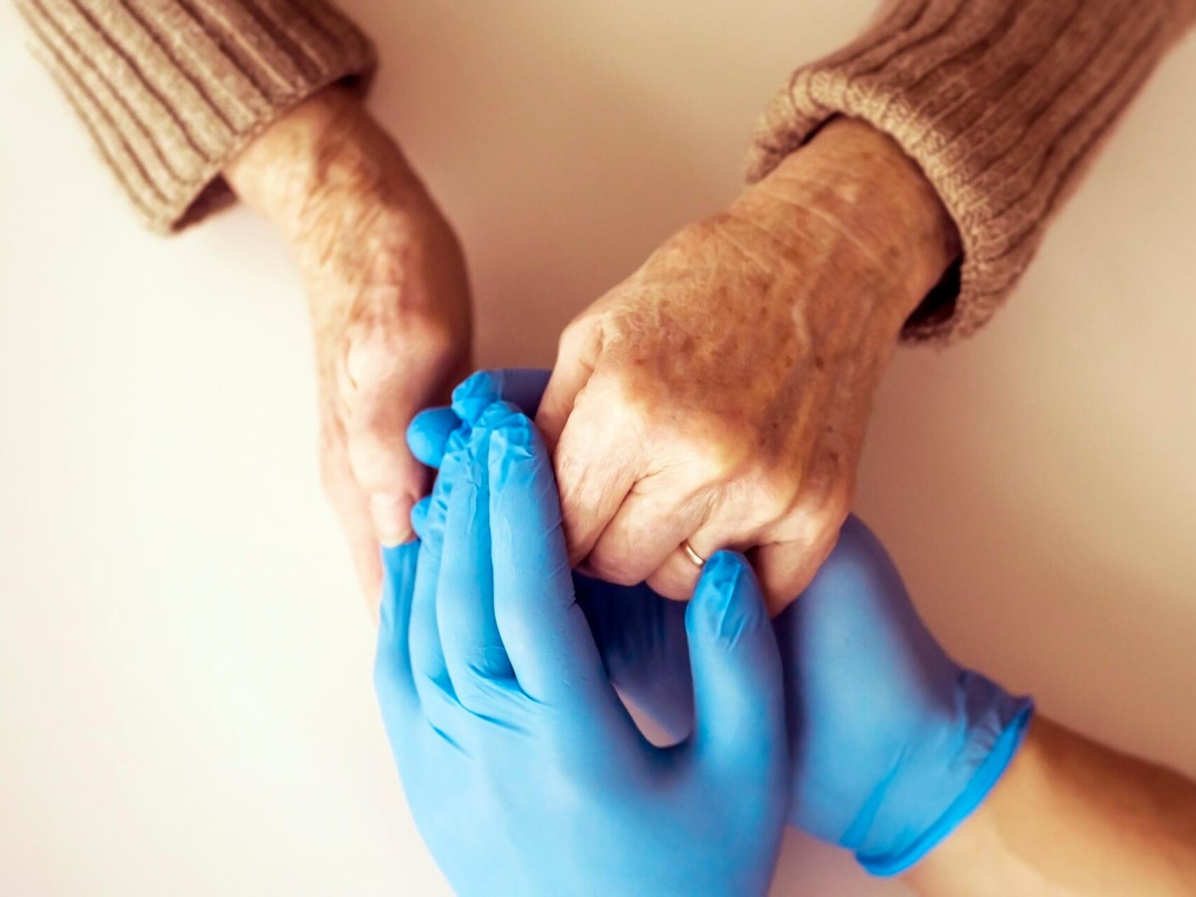 Care home visitor and resident holding hands