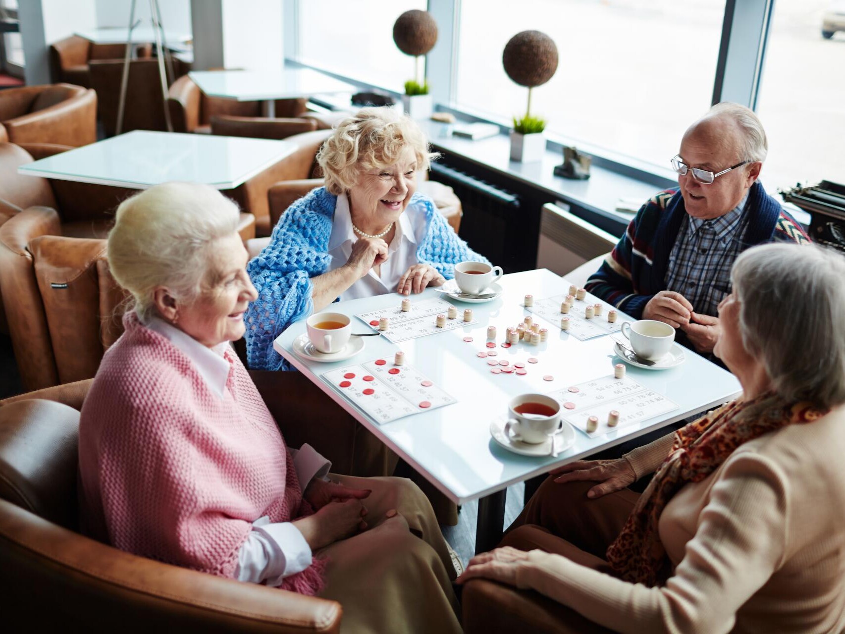 Carless + Adams care home residents playing a board game in the communal living space