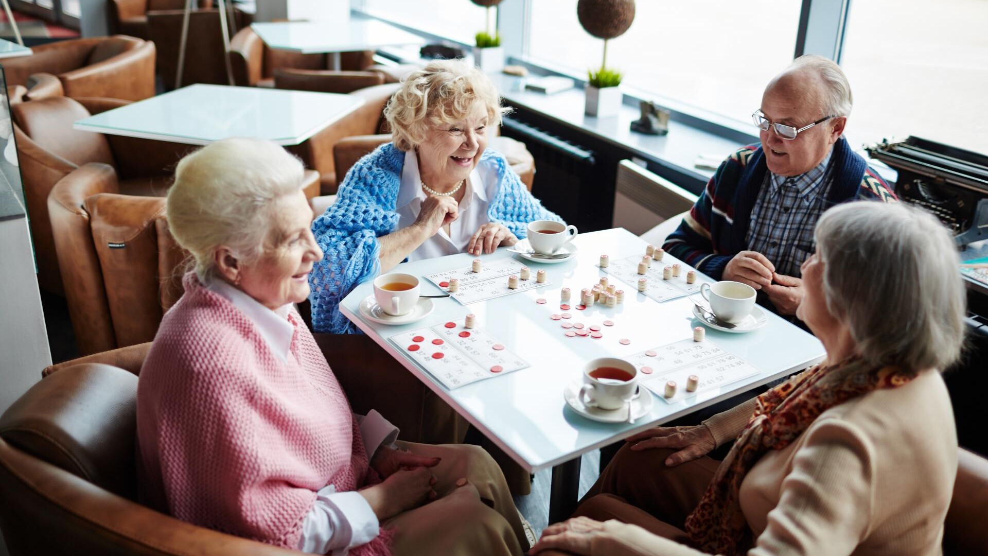 Carless + Adams care home residents playing a board game in the communal living space