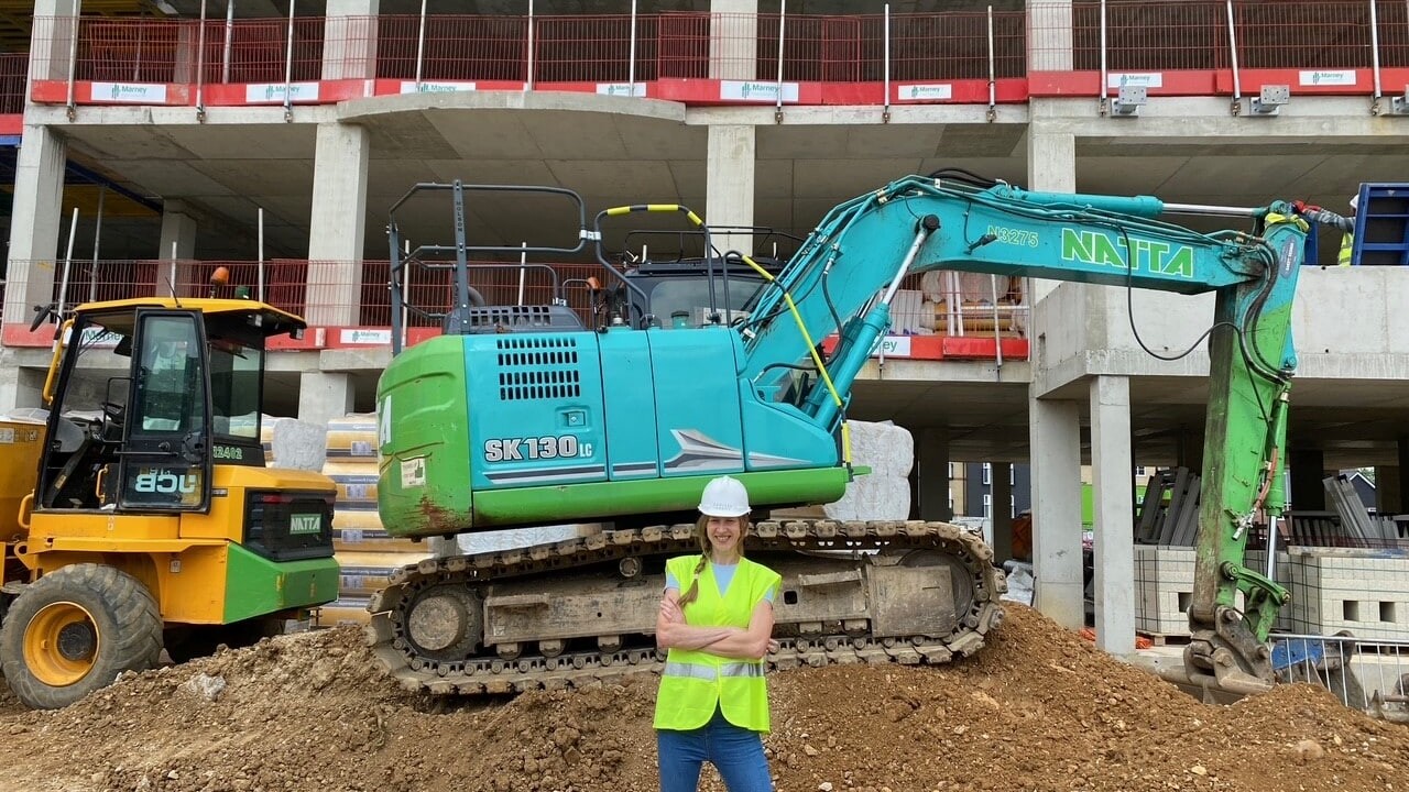 Site isnpection photo of architect in front of a digger
