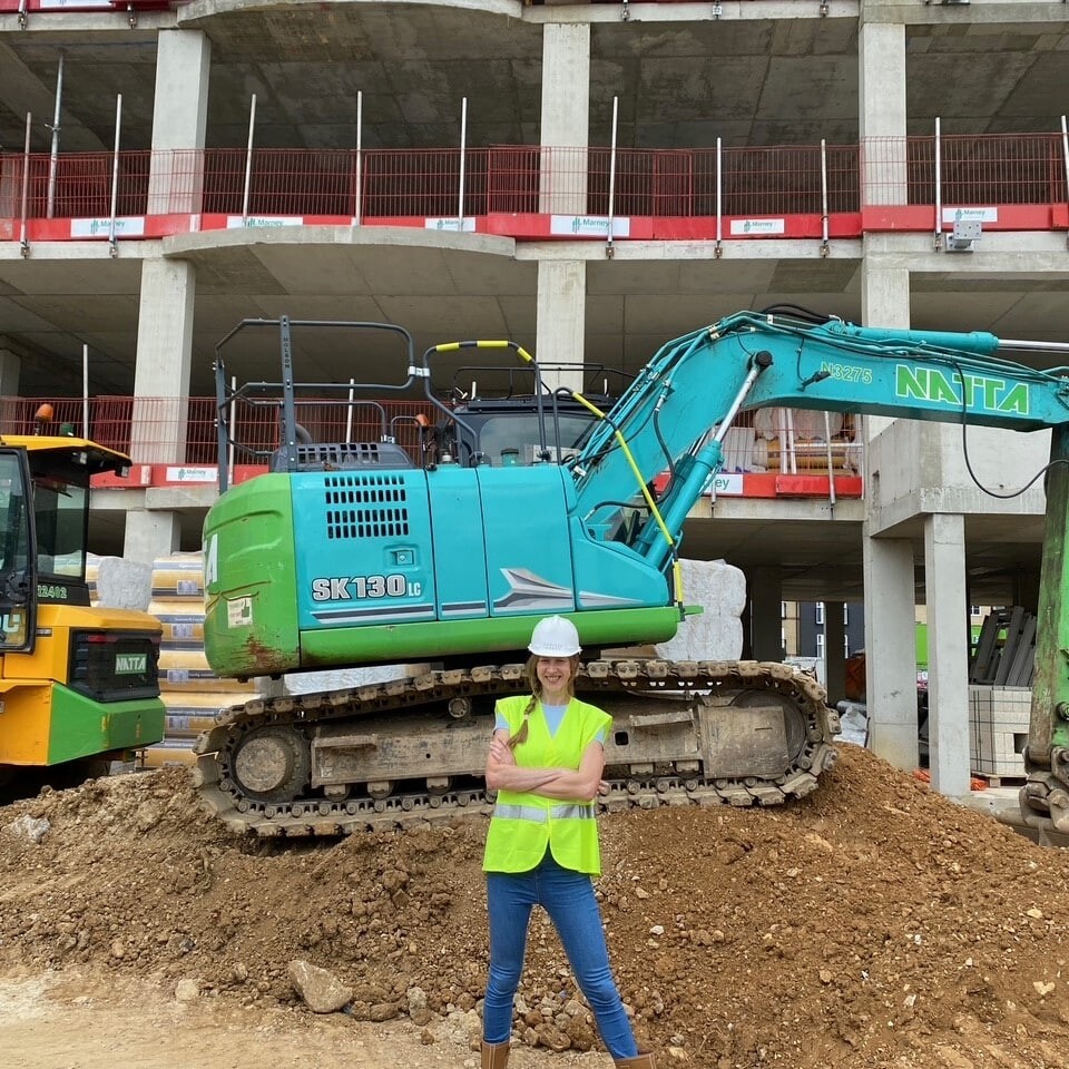 Site isnpection photo of architect in front of a digger